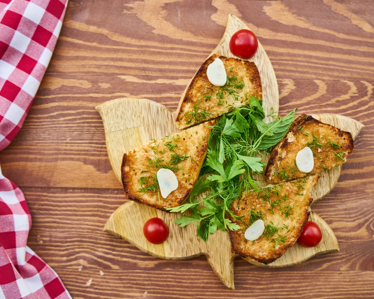 Жареный хлеб на доске с зеленью и помидорами