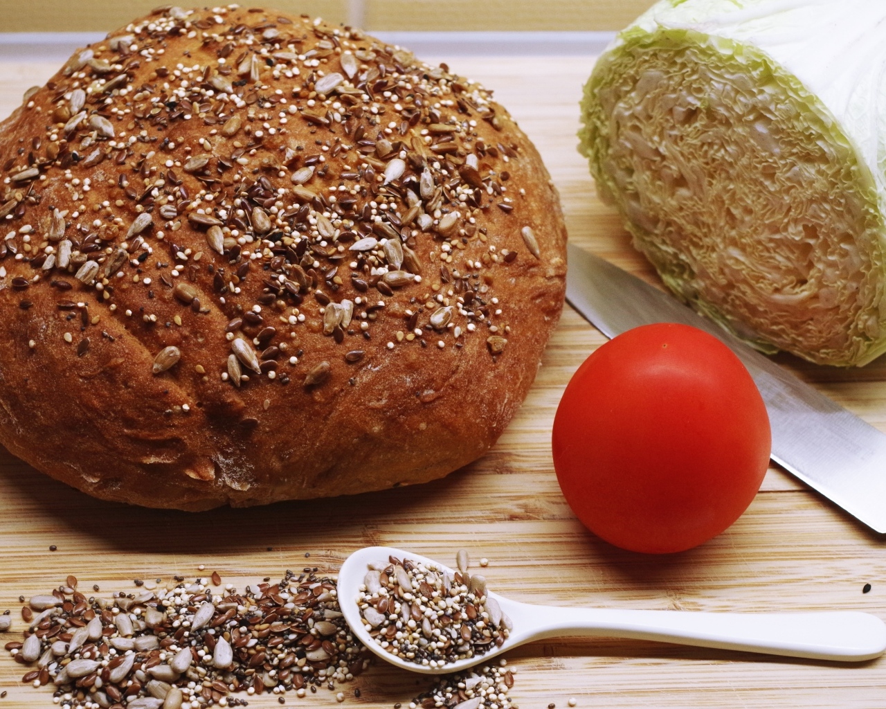 Буханка хлеба на столе с капустой и помидором