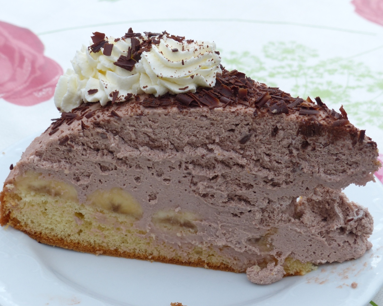 Кусок аппетитного торта с кремом на белой тарелке