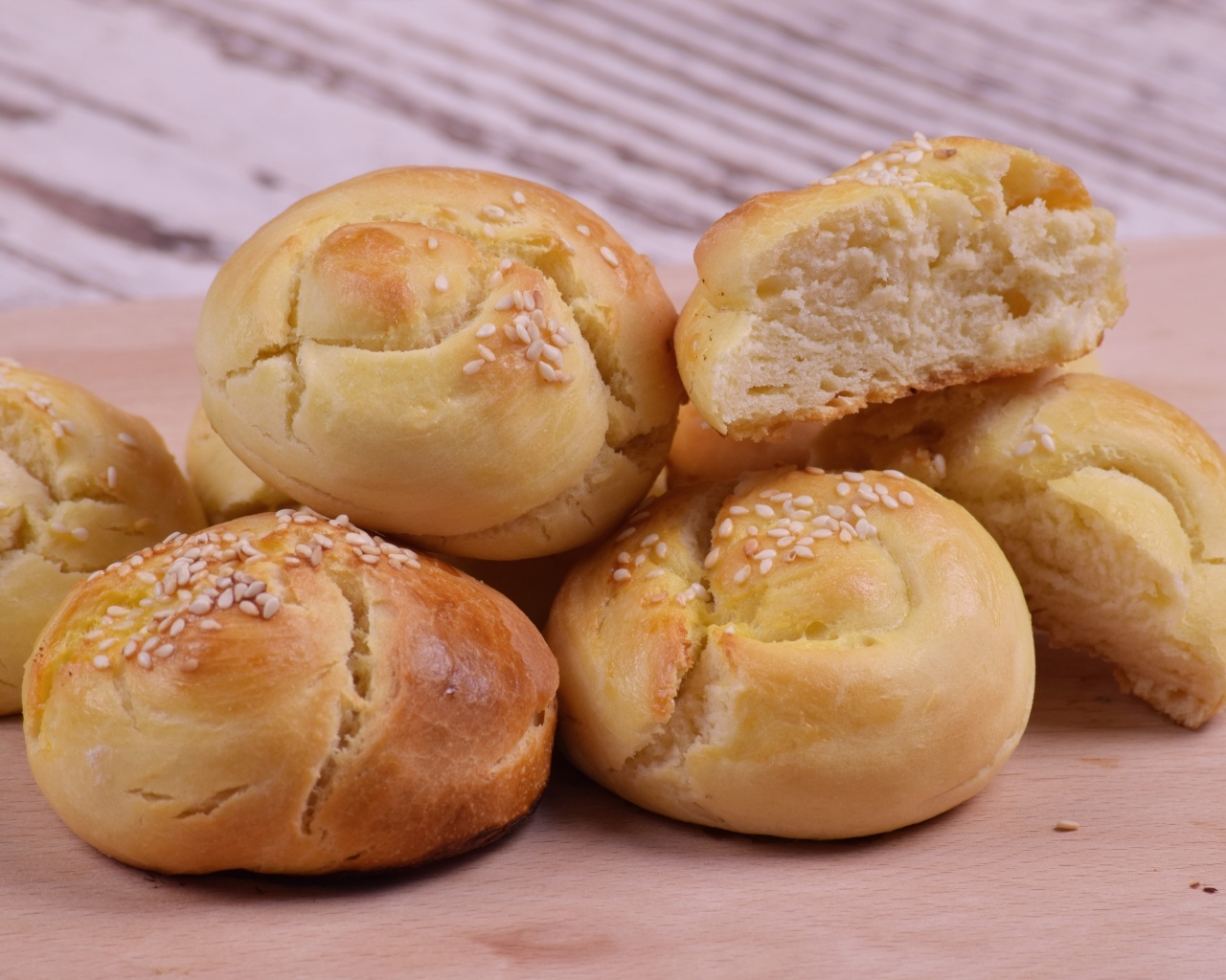Аппетитные сладкие булочки с кунжутом на столе