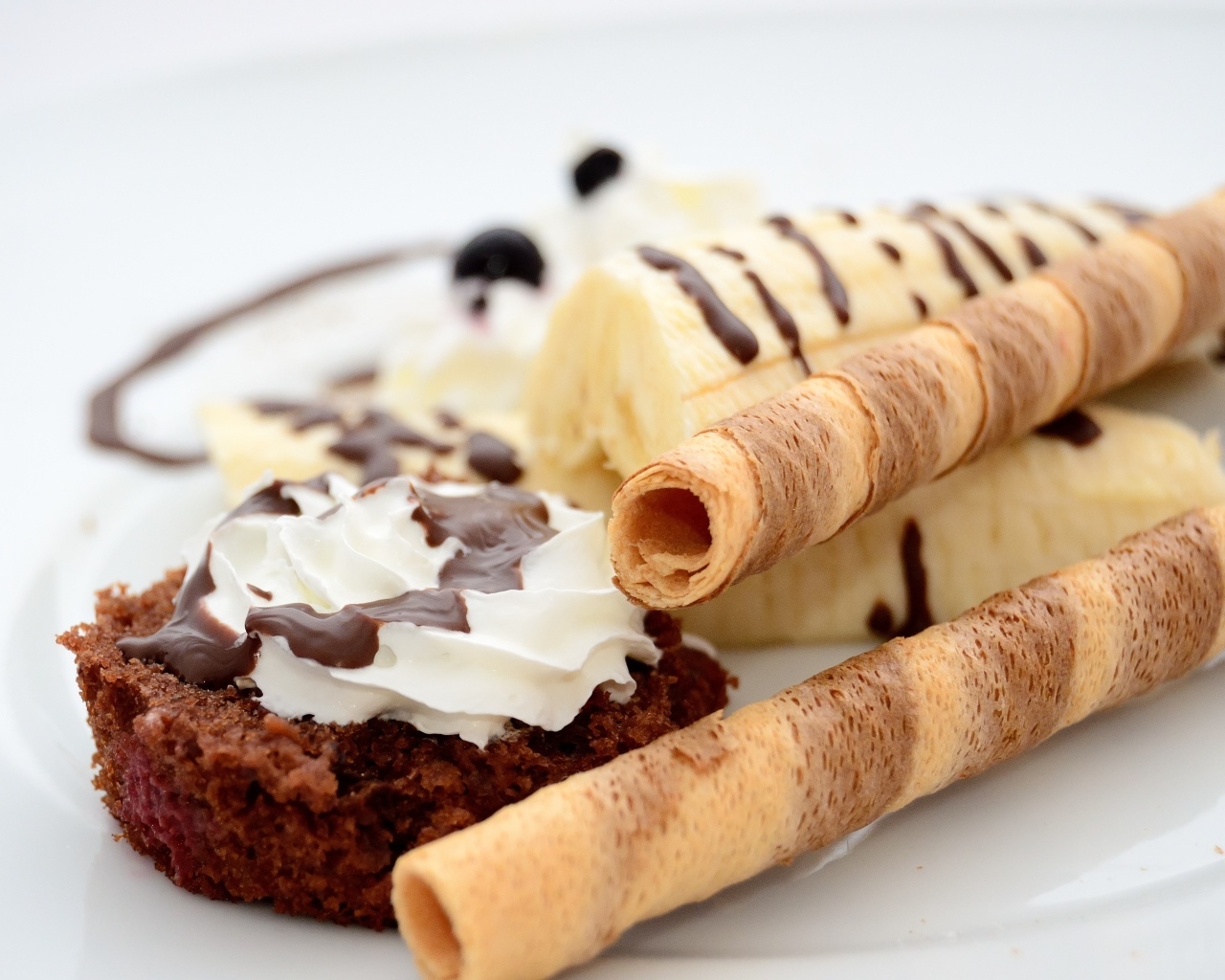 Банан на тарелке с трубочками и кексом