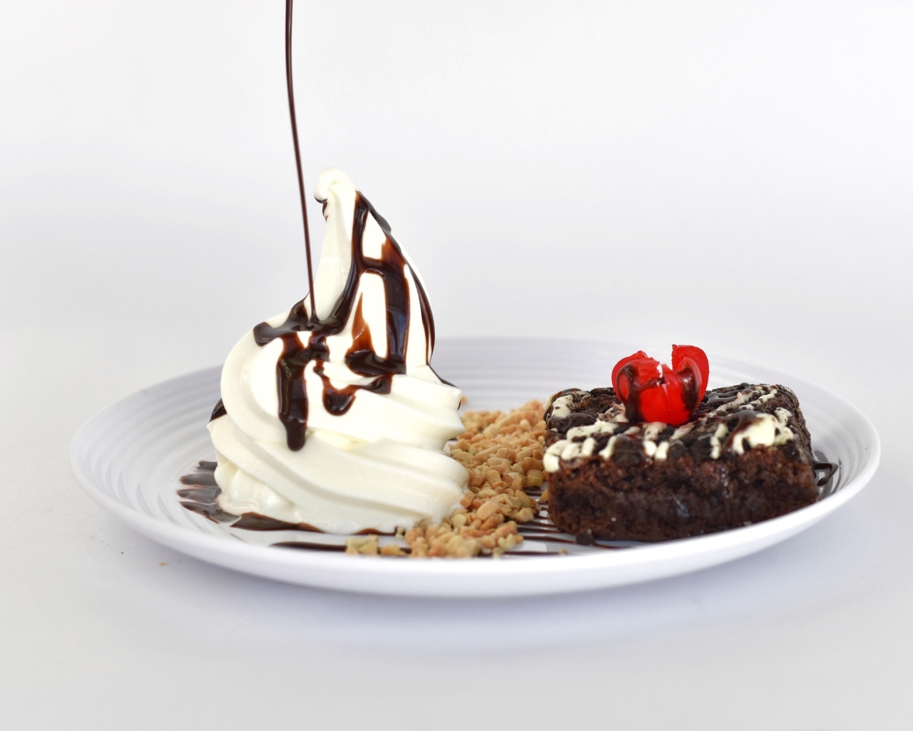 Пирожное со взбитыми сливками на тарелке на белом фоне