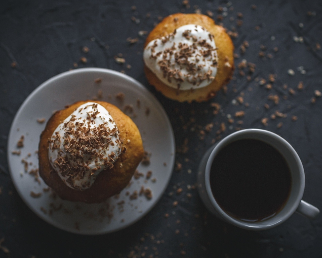 Пирожное в тертым шоколадом на столе с чашкой кофе