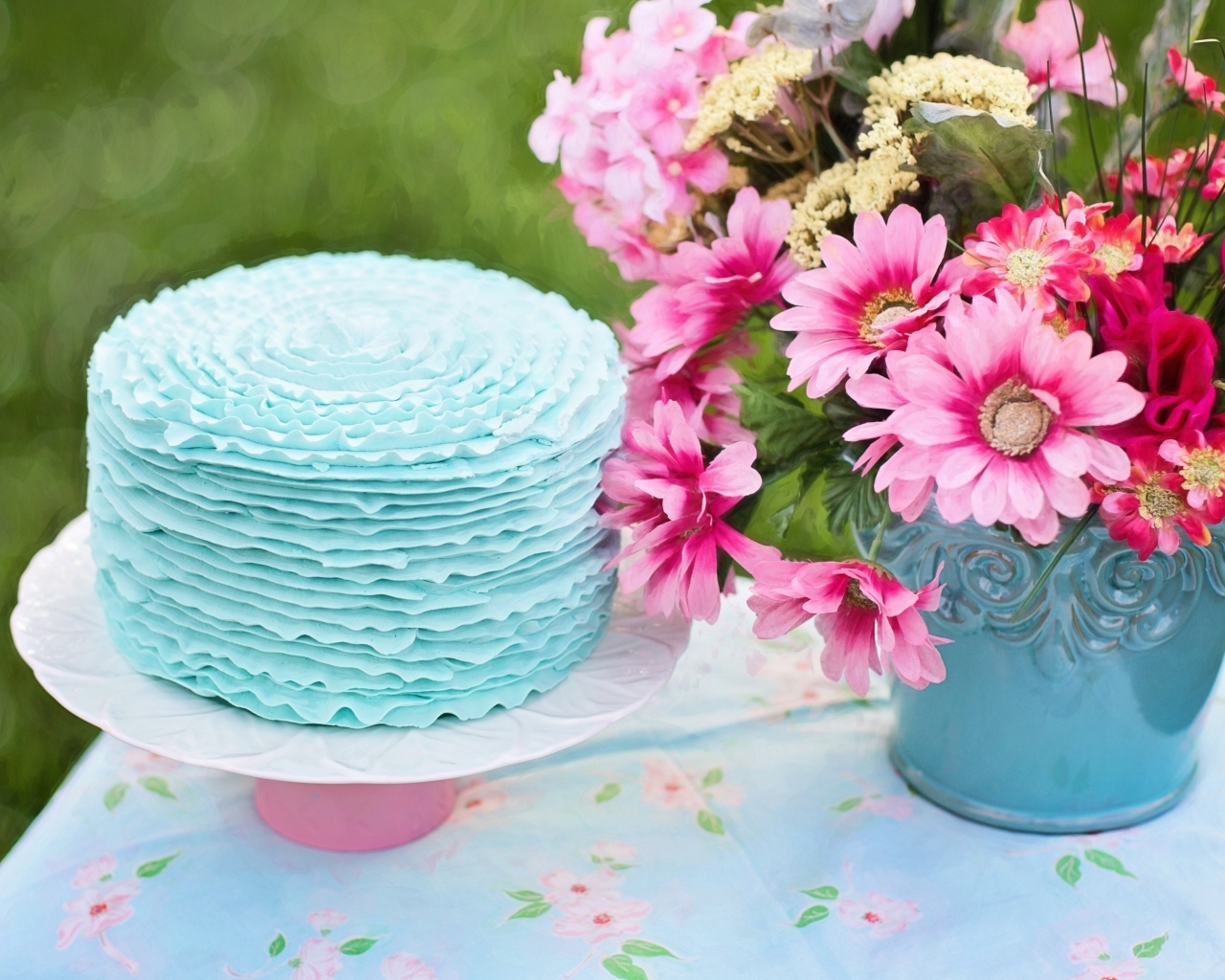 Торт с голубым кремом на столе с цветами