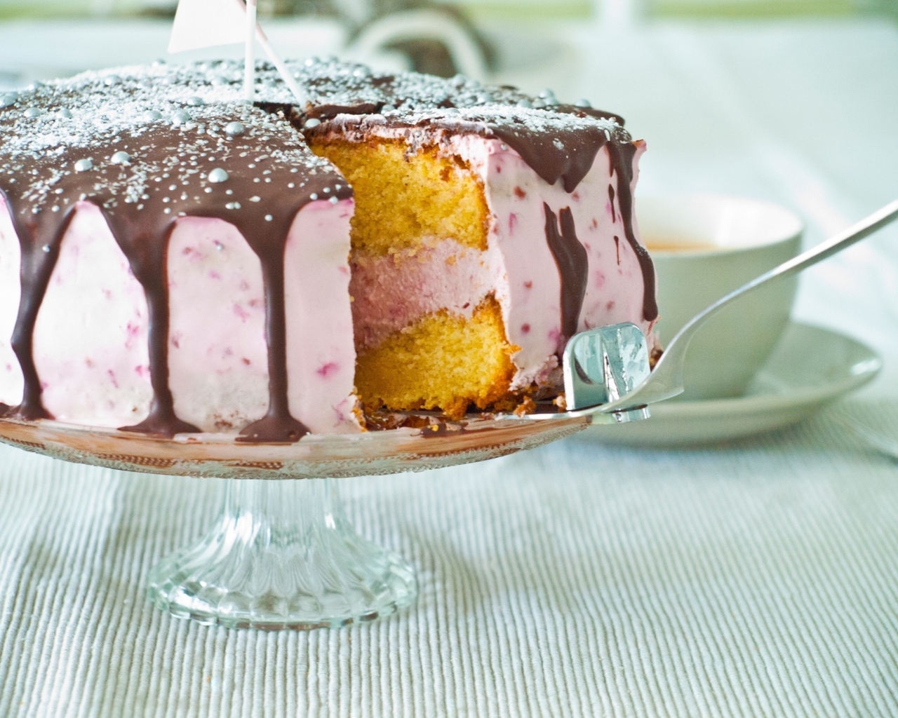 Торт с розовым кремом и шоколадом на столе