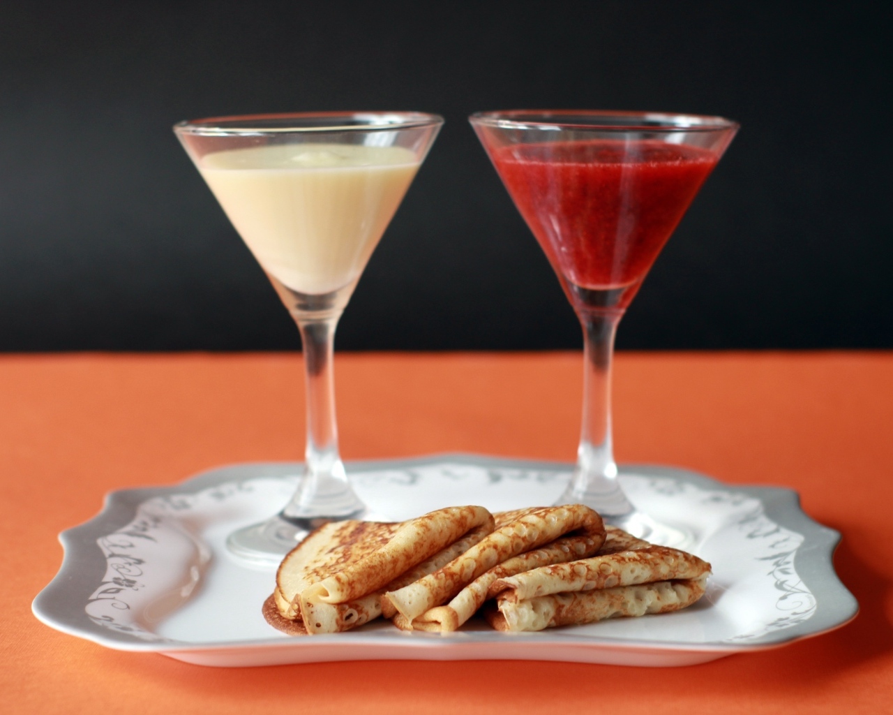 Сгущенка и варенье на тарелке с блинами