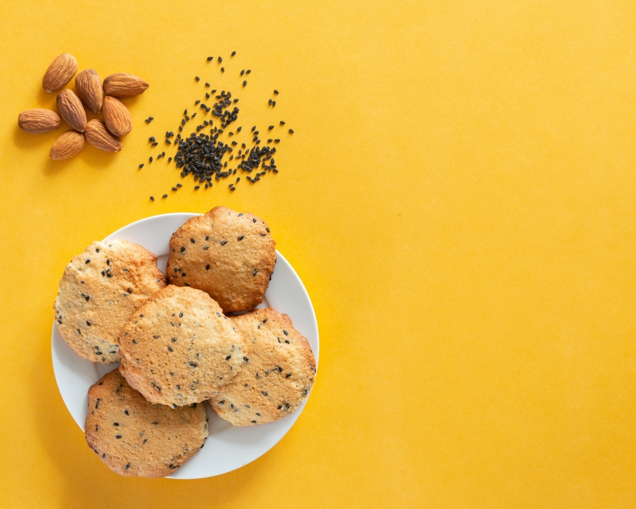 Печенье на желтом фоне с кунжутом и миндальным орехом