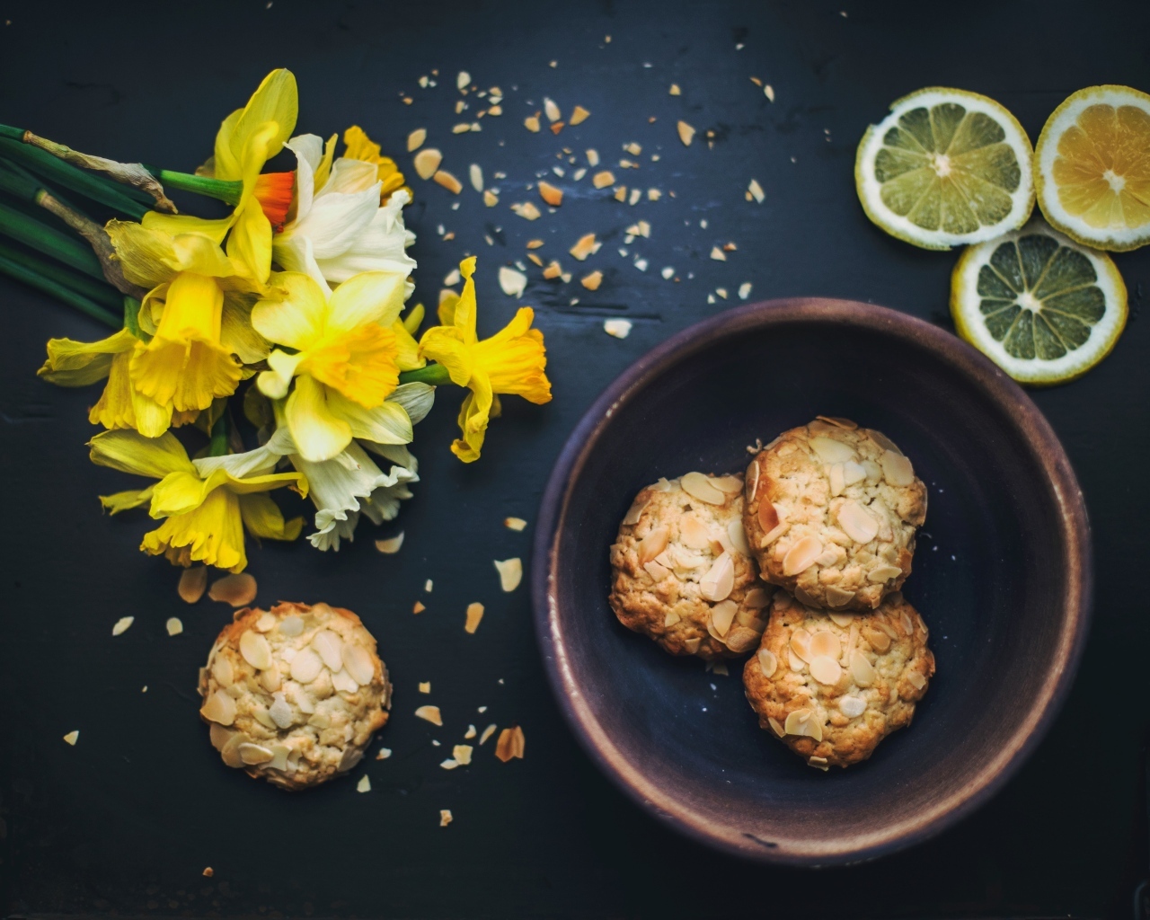 Печенье на столе с лимоном и букетом нарциссов