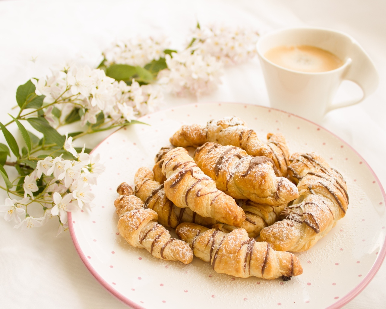 Круассаны на столе с кофе и цветами