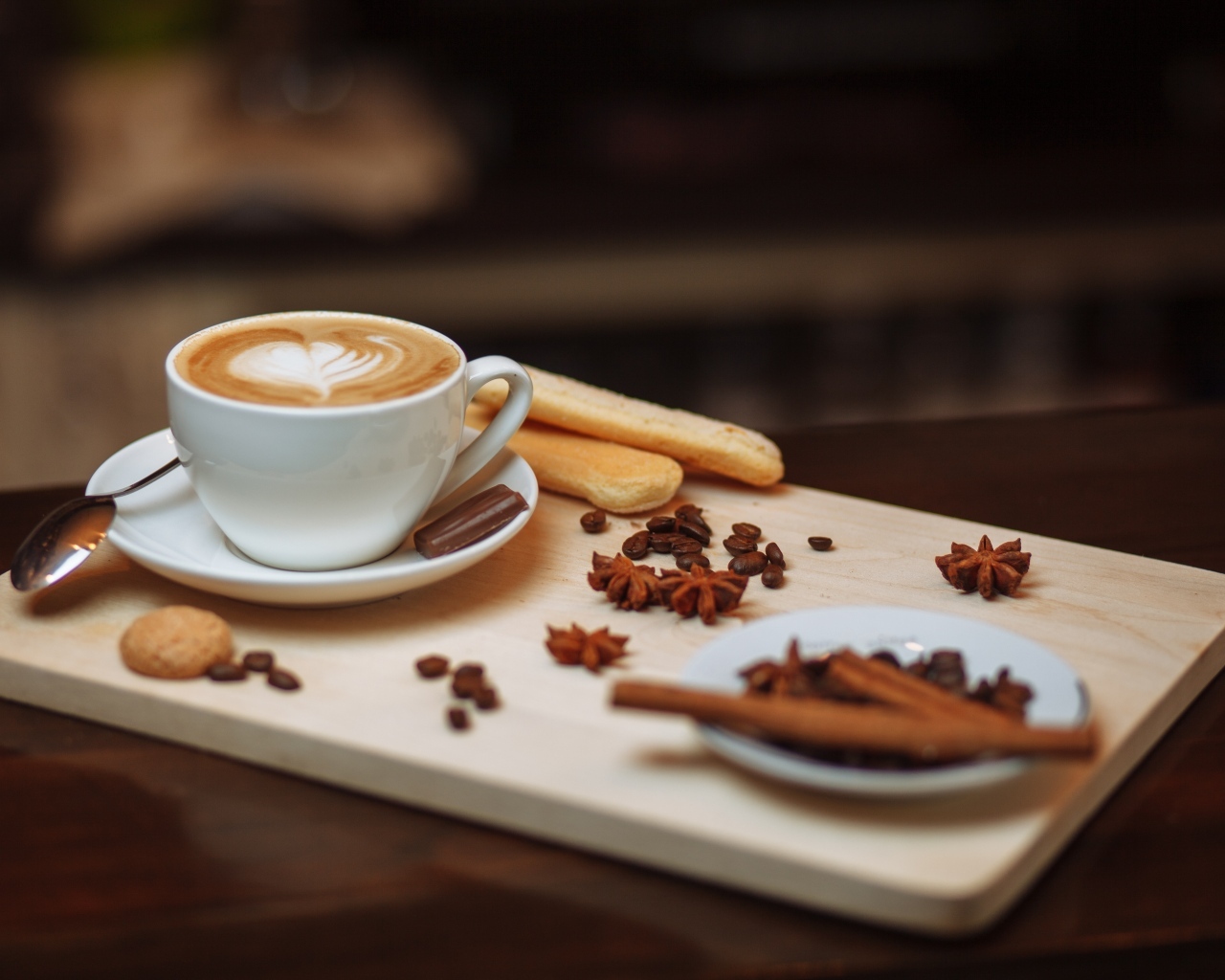 Чашка кофе на доске с печеньем и специями