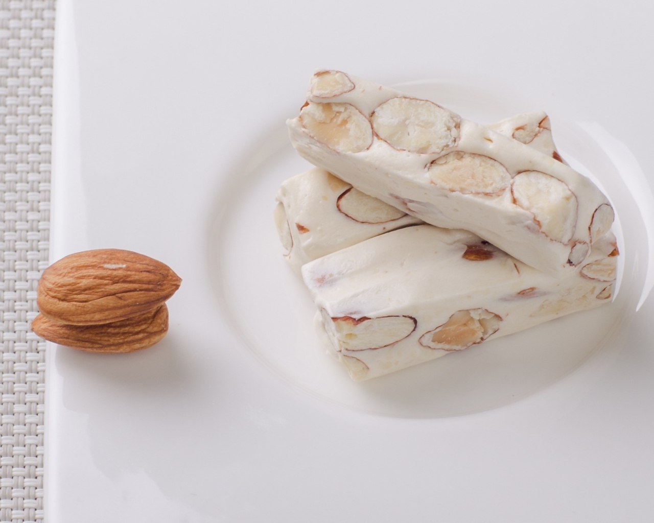 Десерт нуга с миндальными орехами на тарелке 