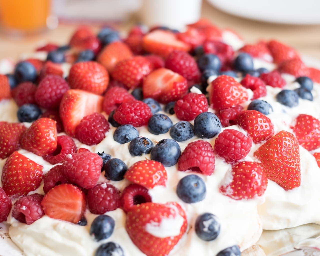 Десерт с кремом и свежими ягодами малины, клубники и черники