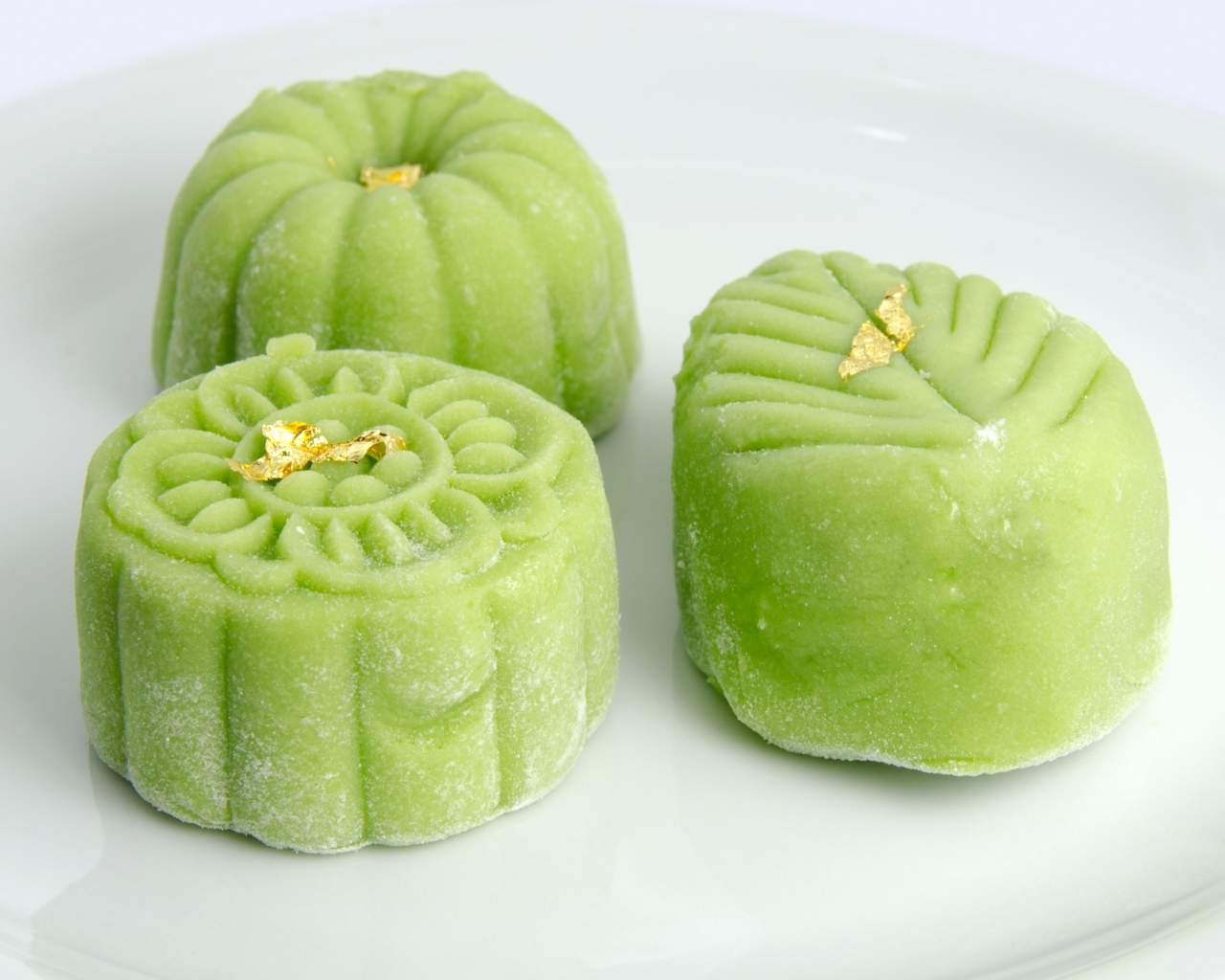 Зеленые конфеты на белой тарелке