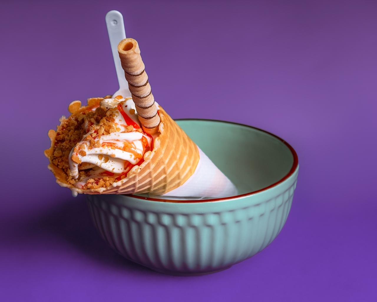 Мороженое рожок с трубочкой на фиолетовом фоне