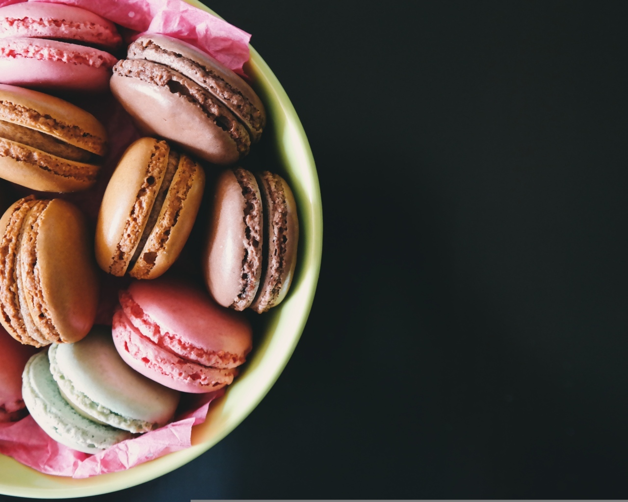 Десерт макарун в миске на черном фоне