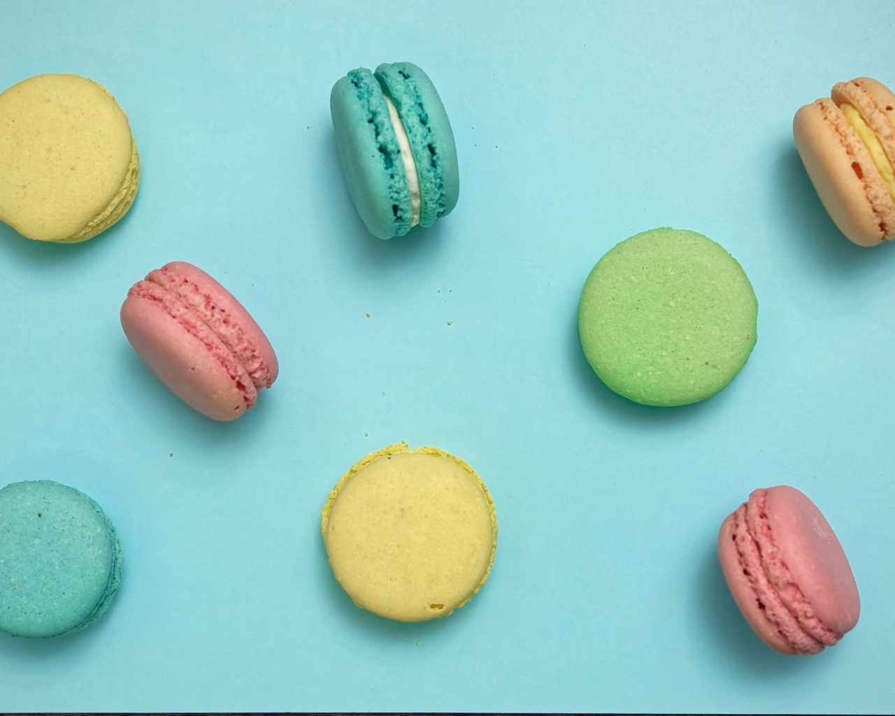 Разноцветный десерт макарон на голубом фоне