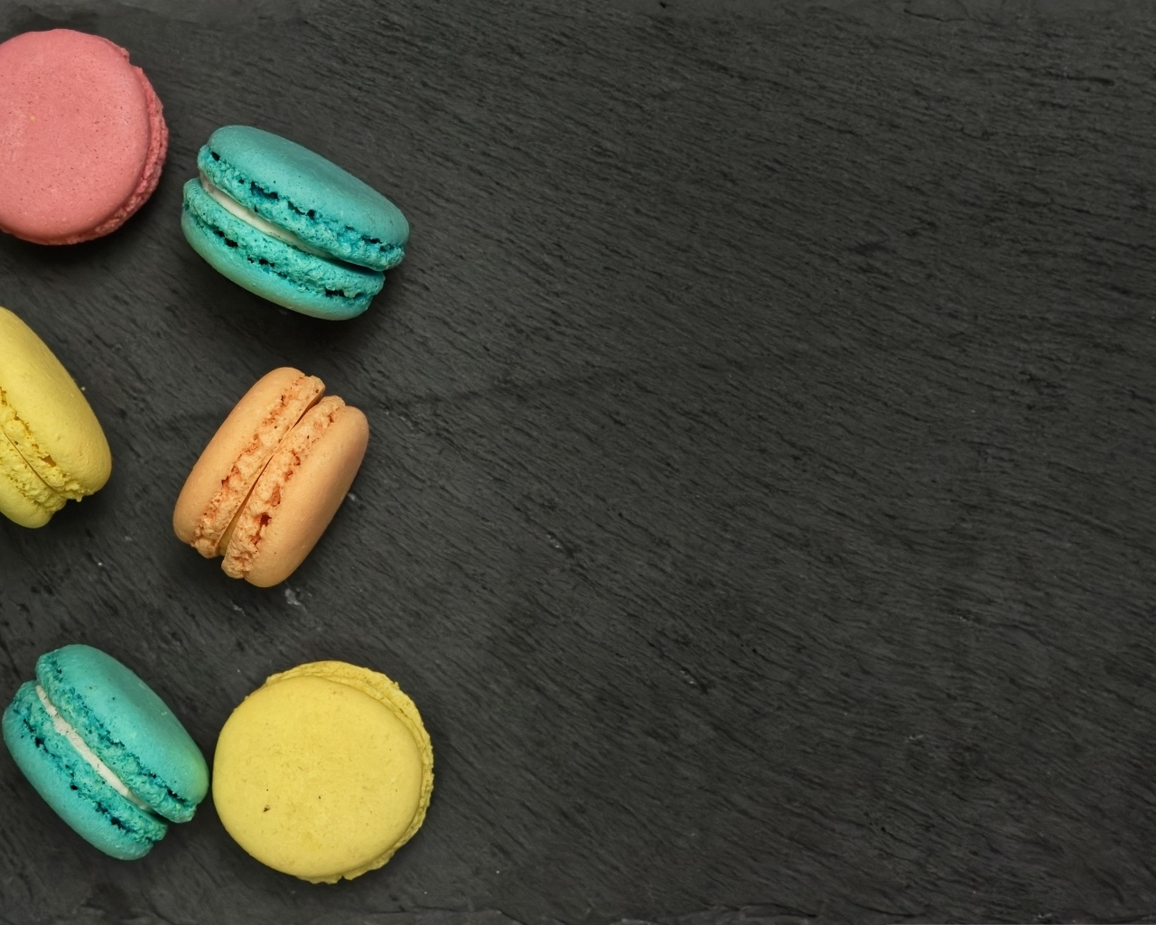 Разноцветный десерт макарон на сером столе