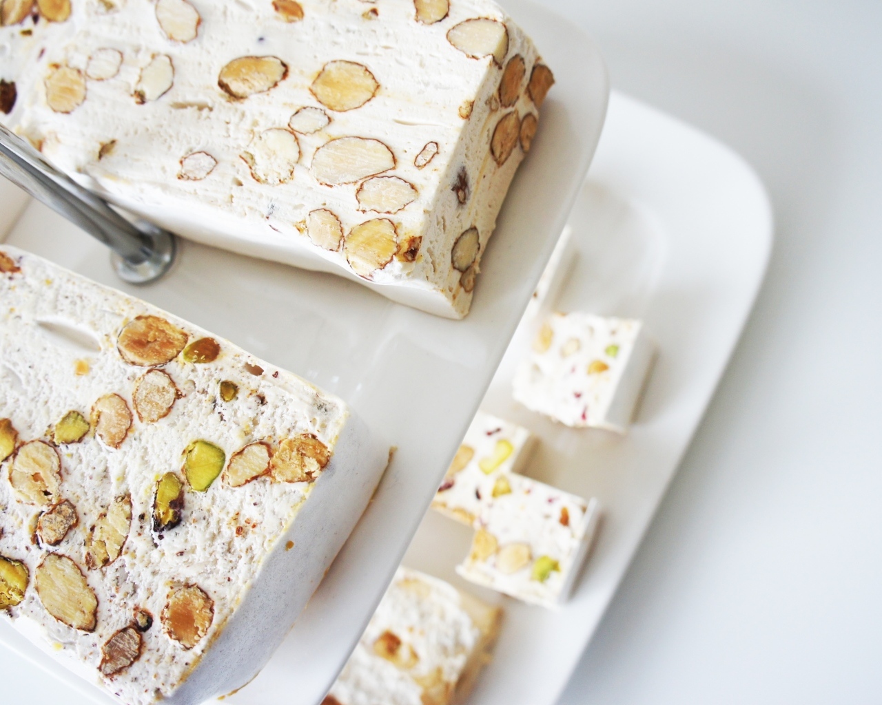 Нуга с орехами на белой тарелке