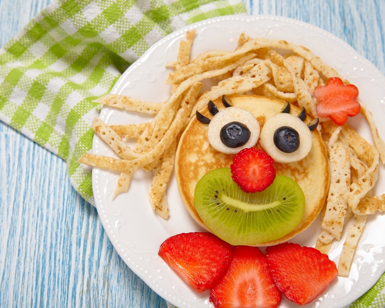 Блины с ягодами на тарелке для ребенка