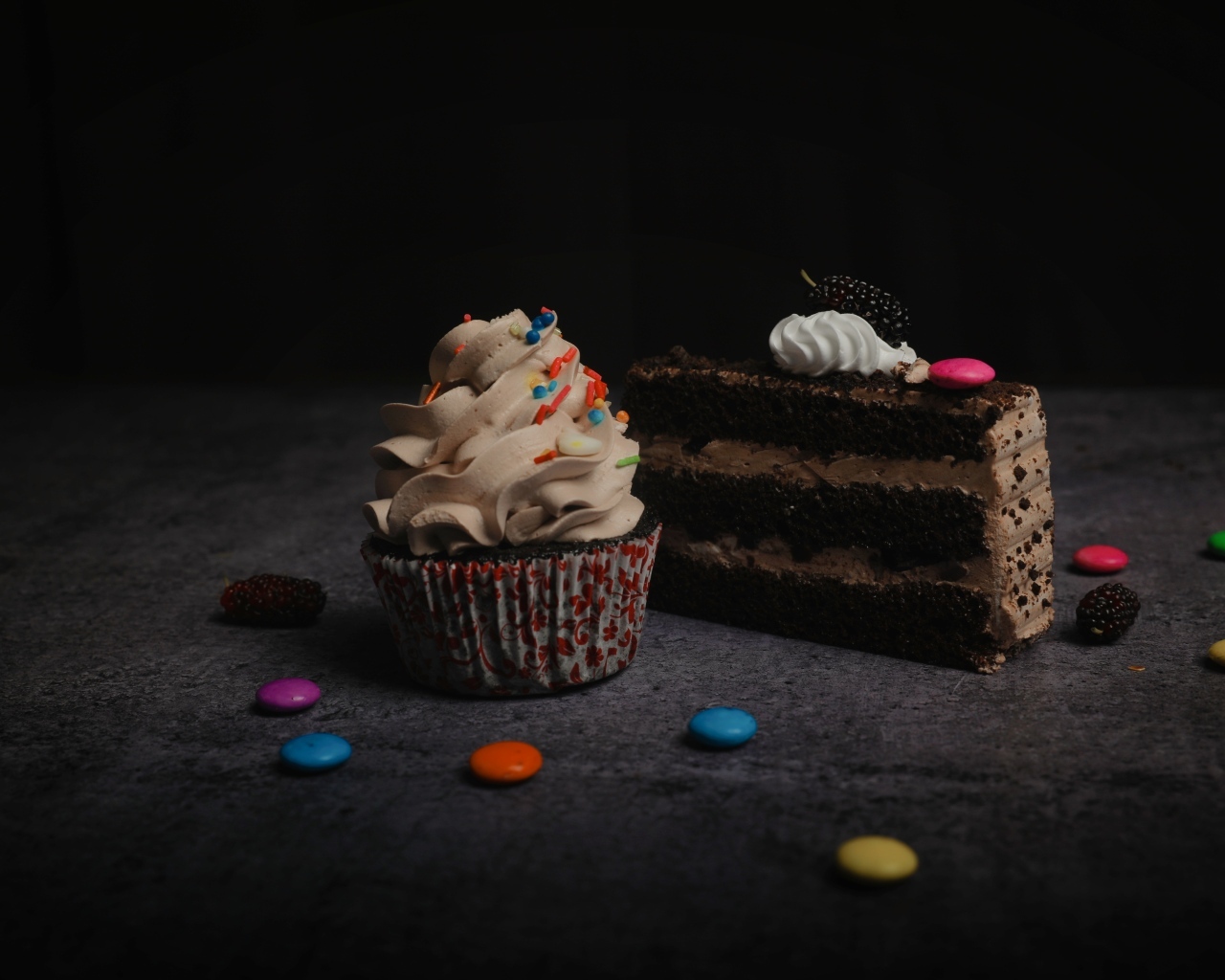 Кусок торта и кекс с кремом на столе