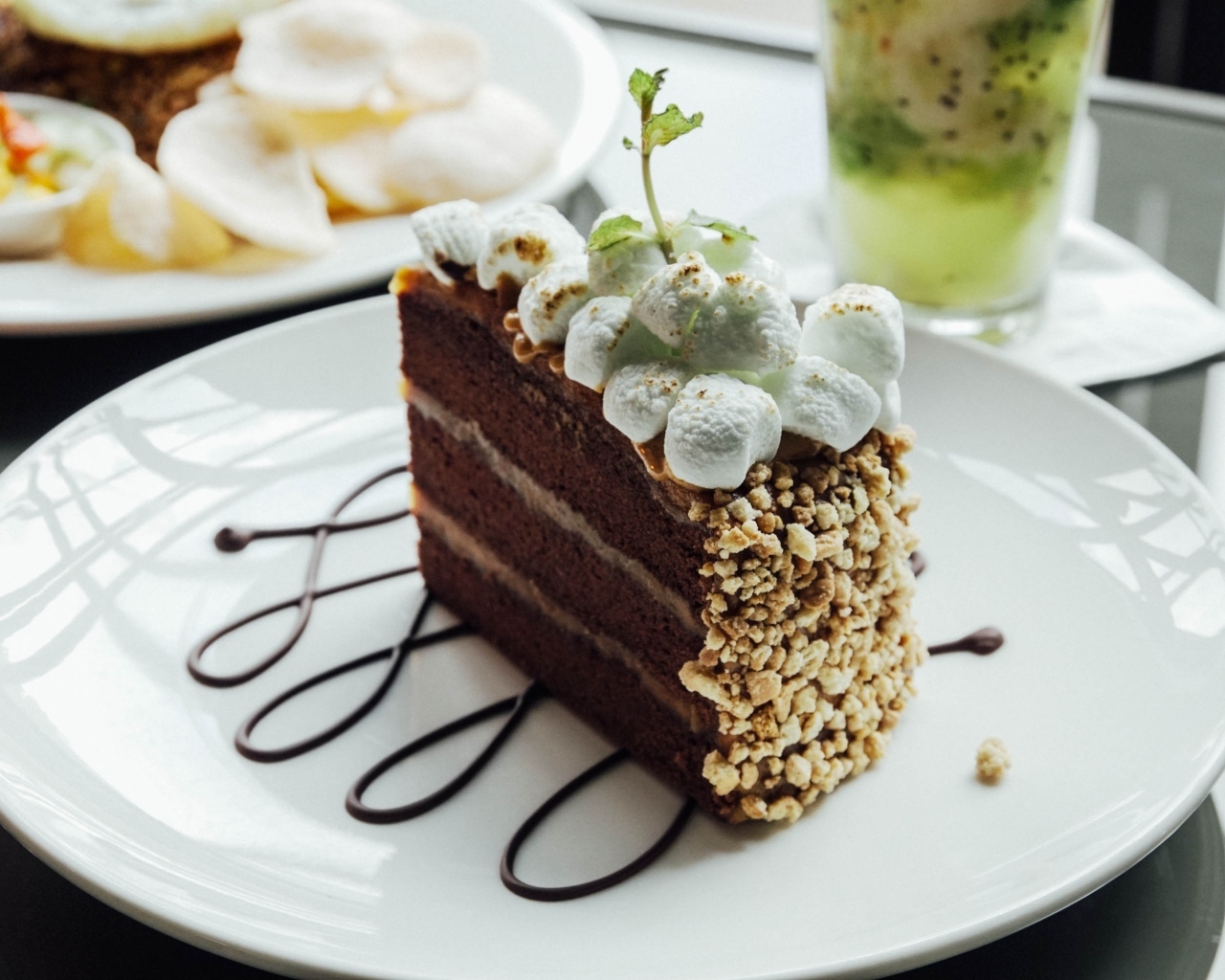 Кусок шоколадного торта с маршмеллоу на белой  тарелке