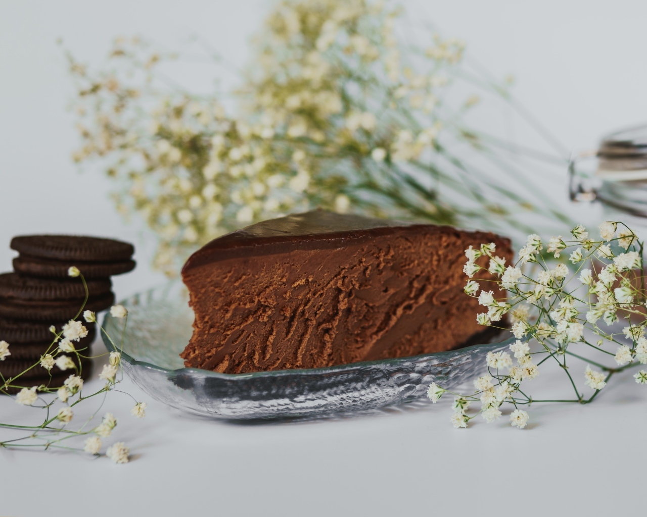 Кусок шоколадного пирога с белыми цветами гипсофилы