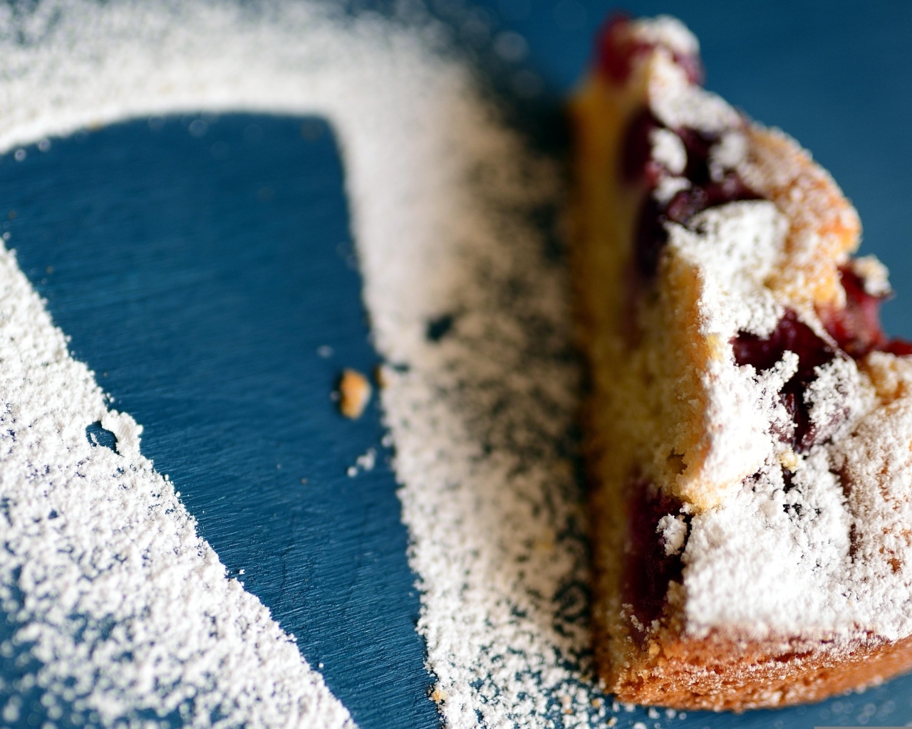 Кусок пирога с ягодами на столе с сахарной пудрой