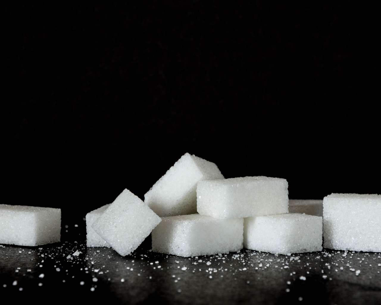 Кусочки сахара на черном фоне