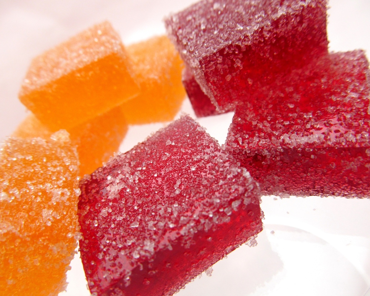 Куски сладкого ягодного мармелада на белом фоне