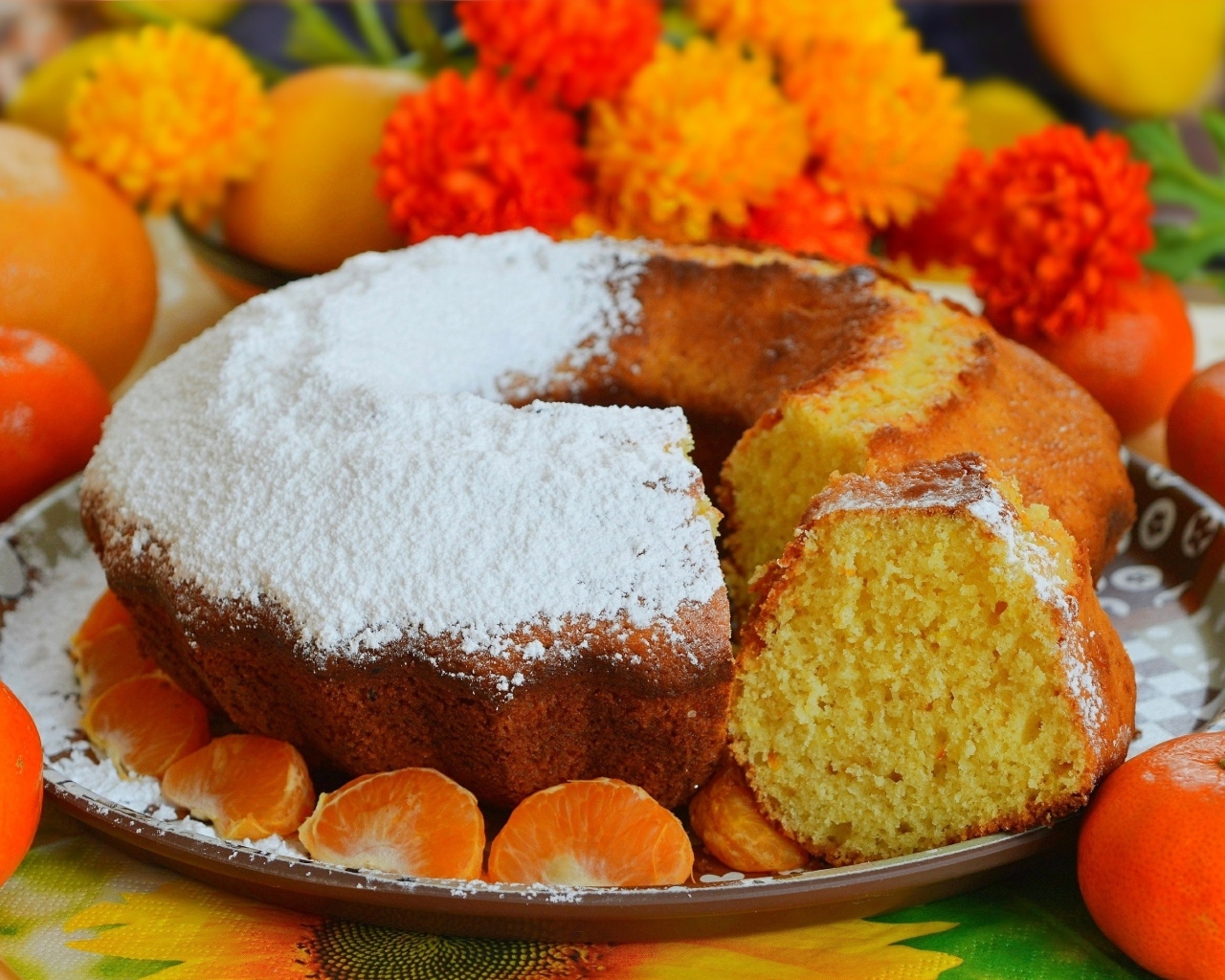 Сладкий пирог на столе с мандаринами и апельсинами