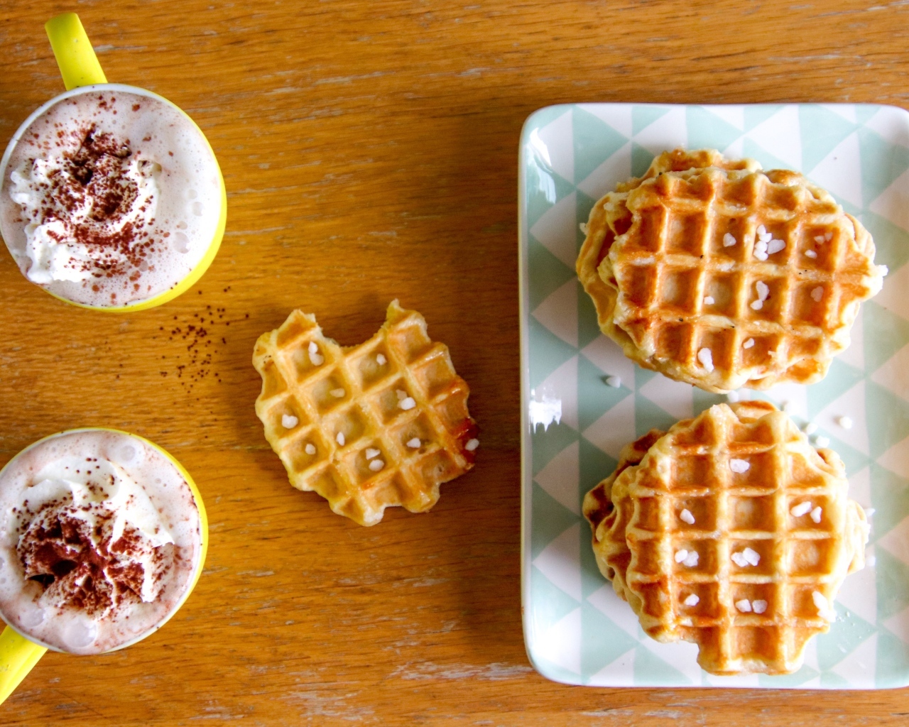 Сладкие вафли на столе с капучино