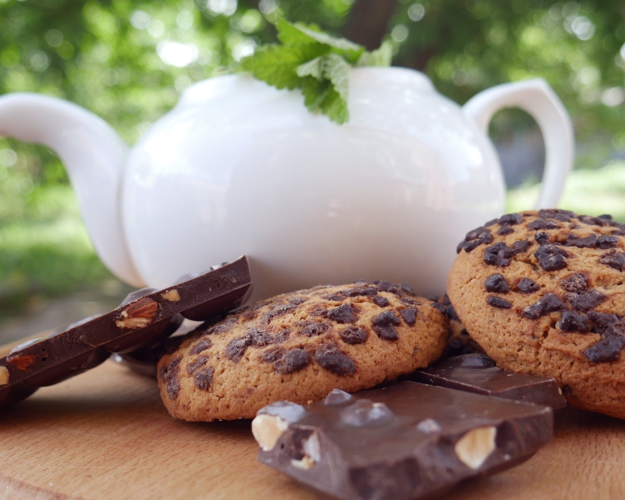 Чайник на столе с печеньем и шоколадом