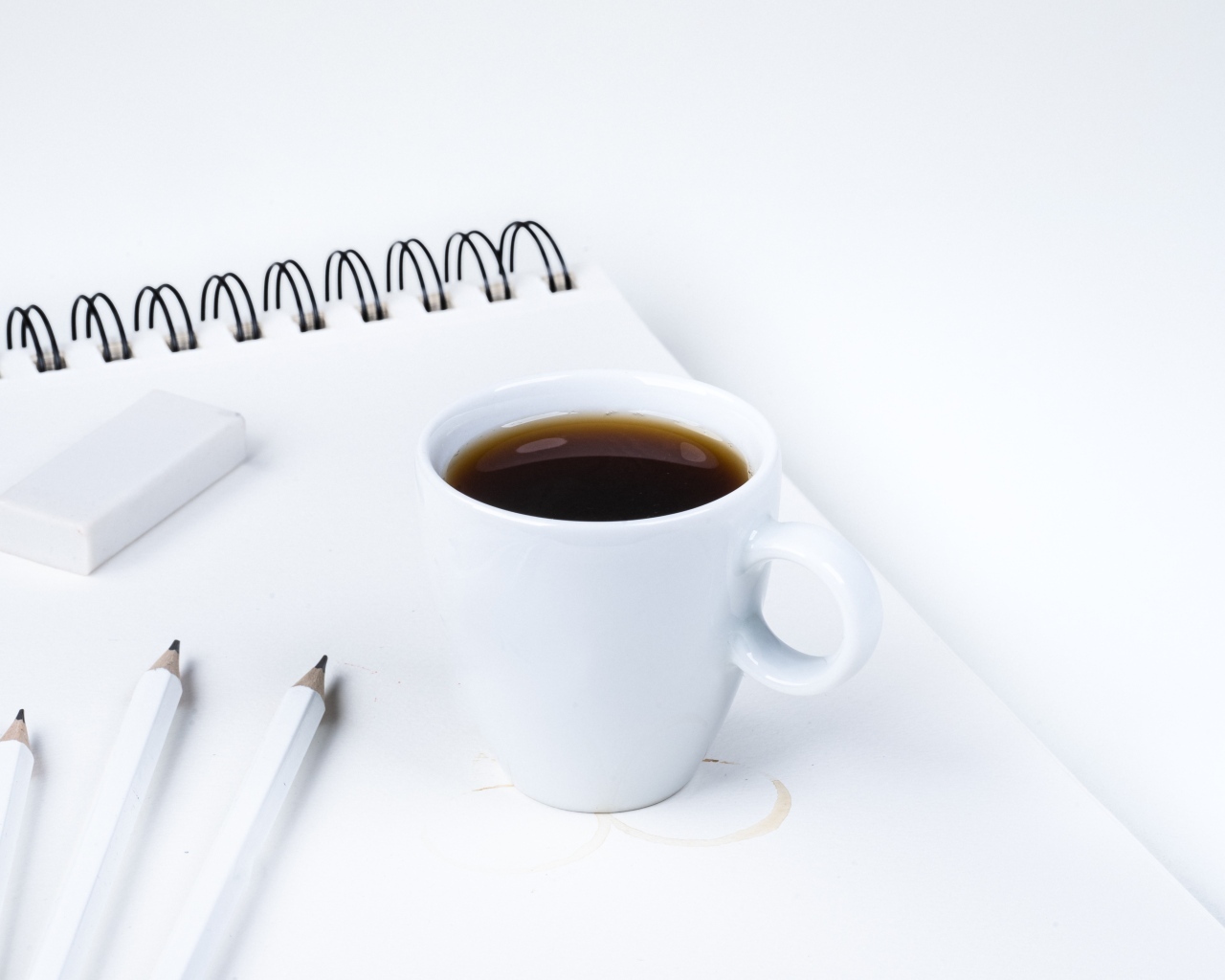 Чашка ароматного кофе с блокнотом на столе
