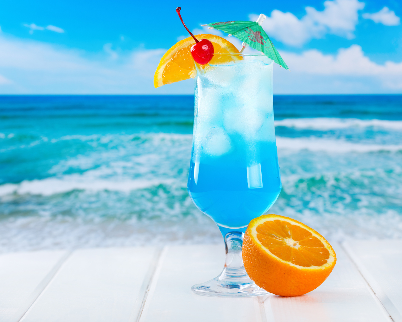 Голубой коктейль со льдом и половинкой апельсина