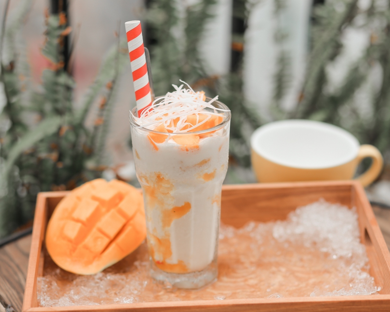 Коктейль с манго в стакане на столе