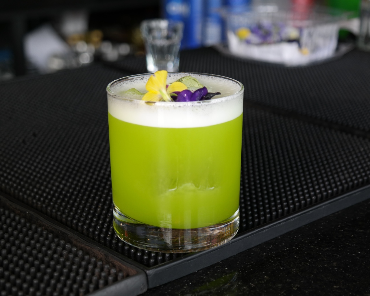 Зеленый коктейль в стакане с цветами