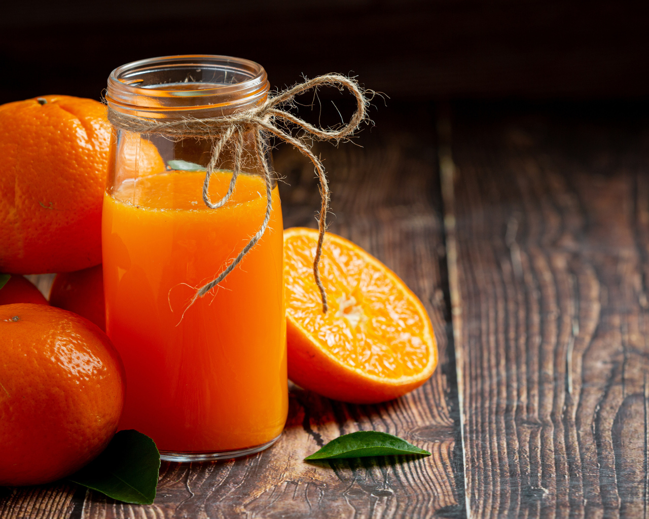 Банка свежего сока на столе с мандаринами