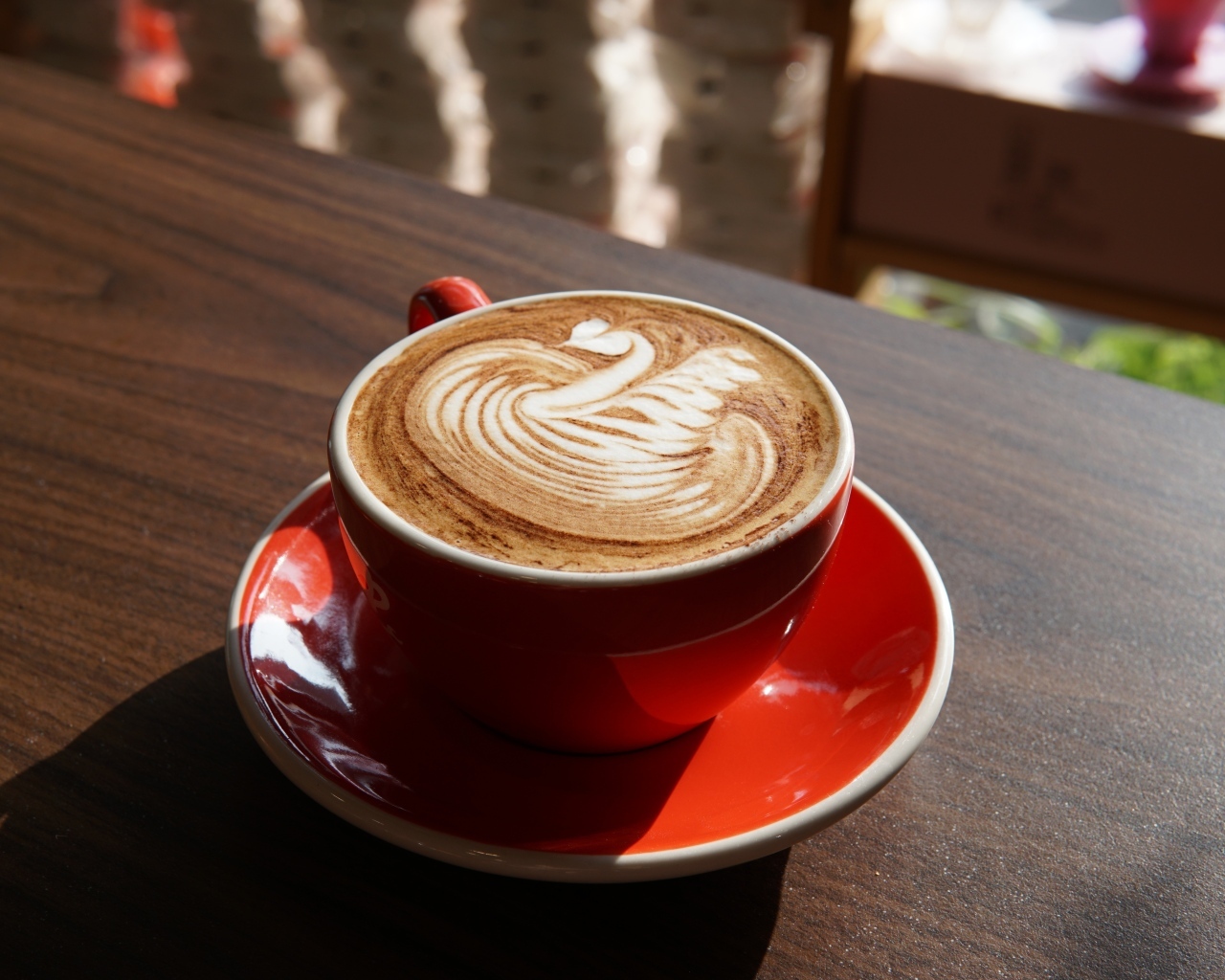 Латте с красивой пенкой в красной чашке