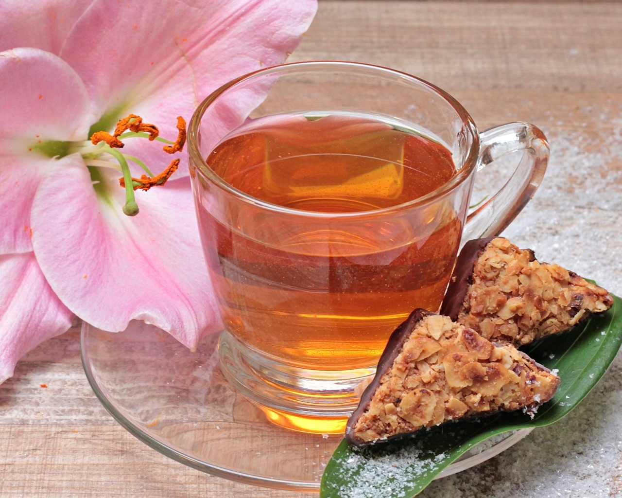 Чай на столе с розовой лилией и конфетами