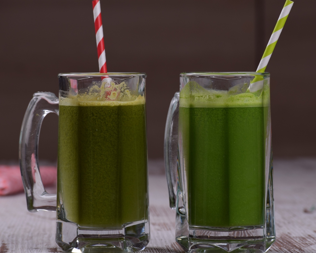 Два стакана зеленого смузи с трубочками
