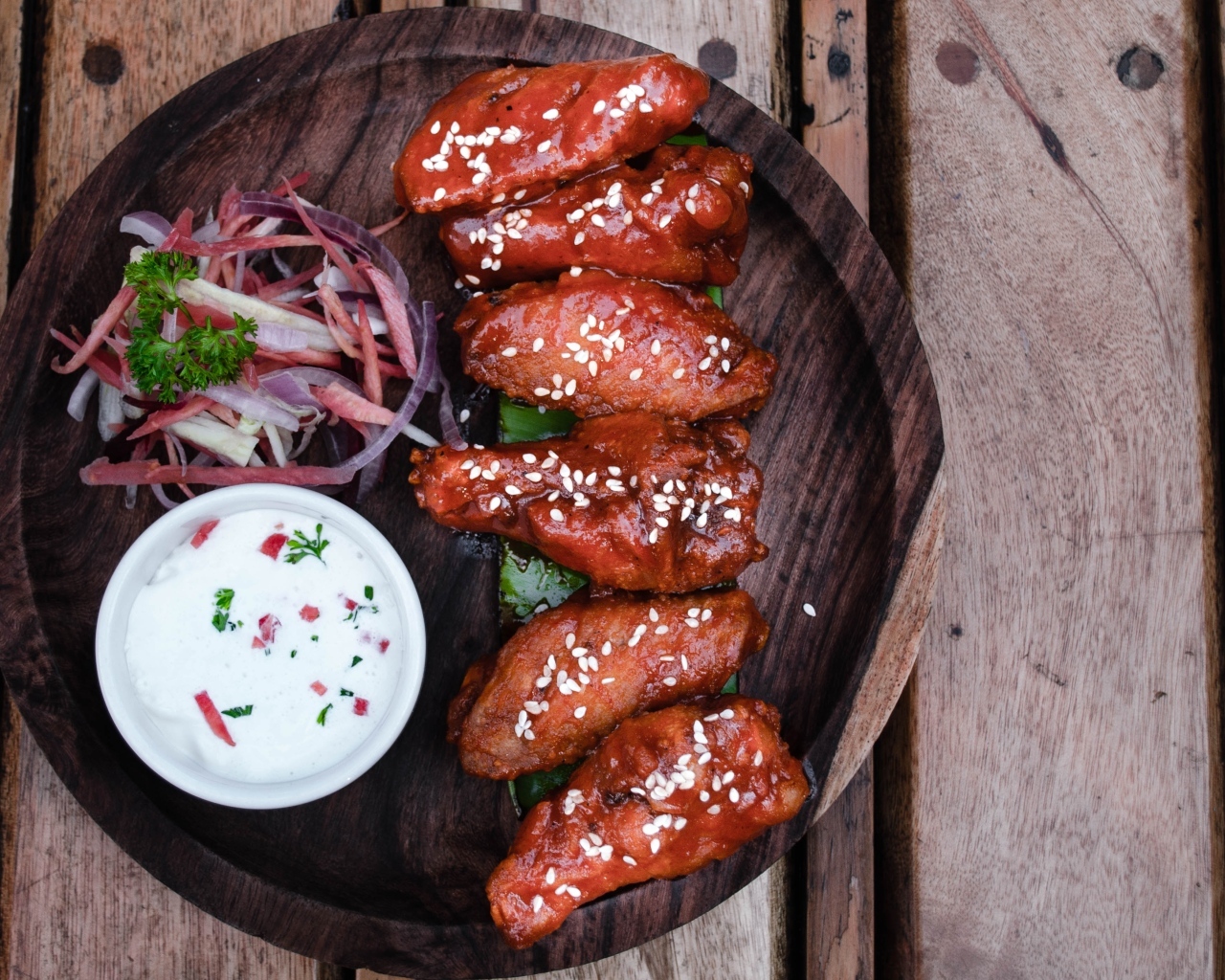 Запеченные куриные крылышки с соусом на тарелке