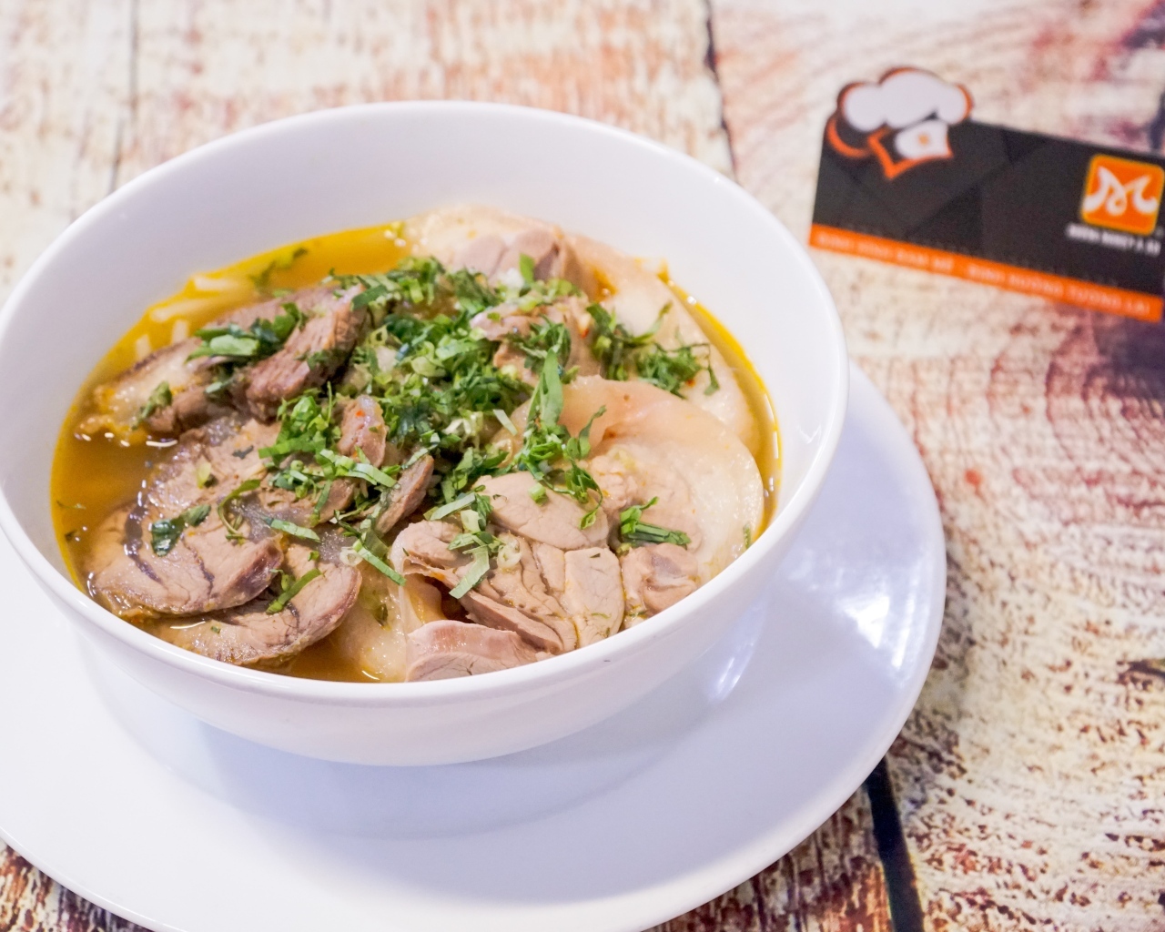 Бульон с мясом в белой тарелке на столе