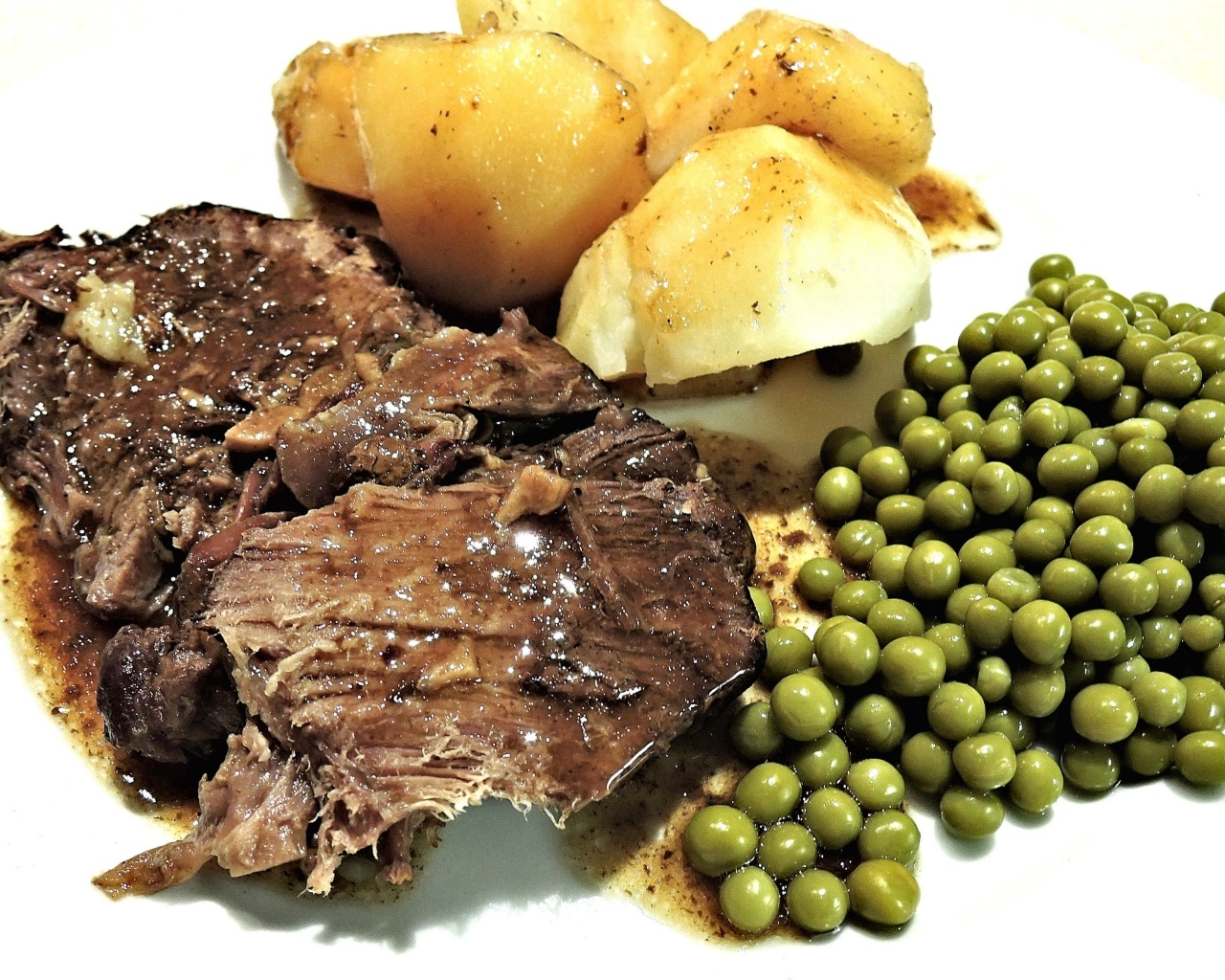 Кусок мяса с картофелем и зеленым горошком