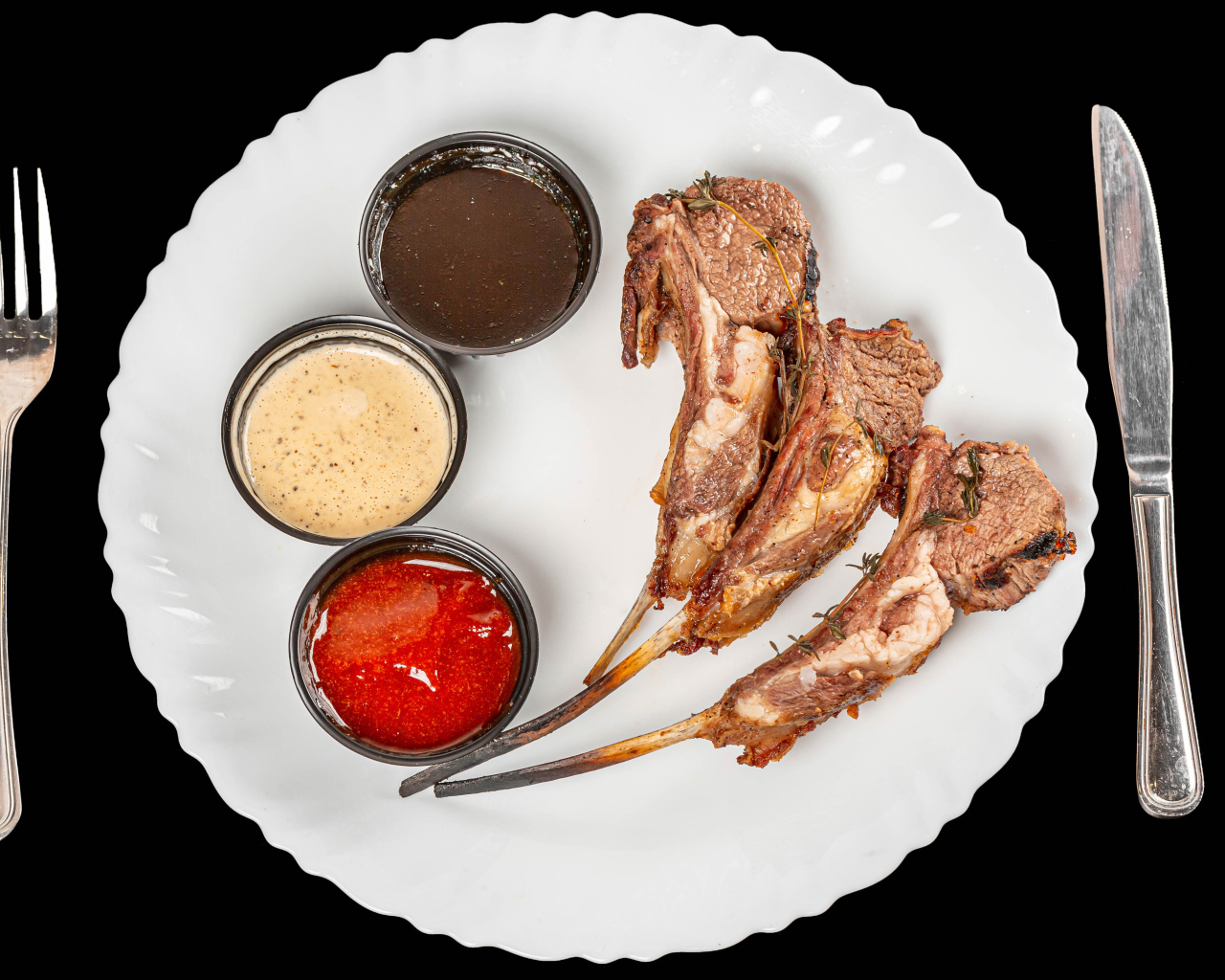 Свиные ребра с соусом на белой тарелке 