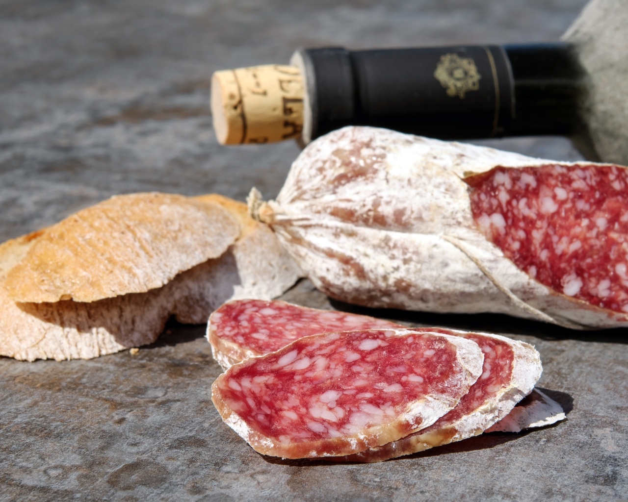 Колбаса салями с хлебом и вином на столе 