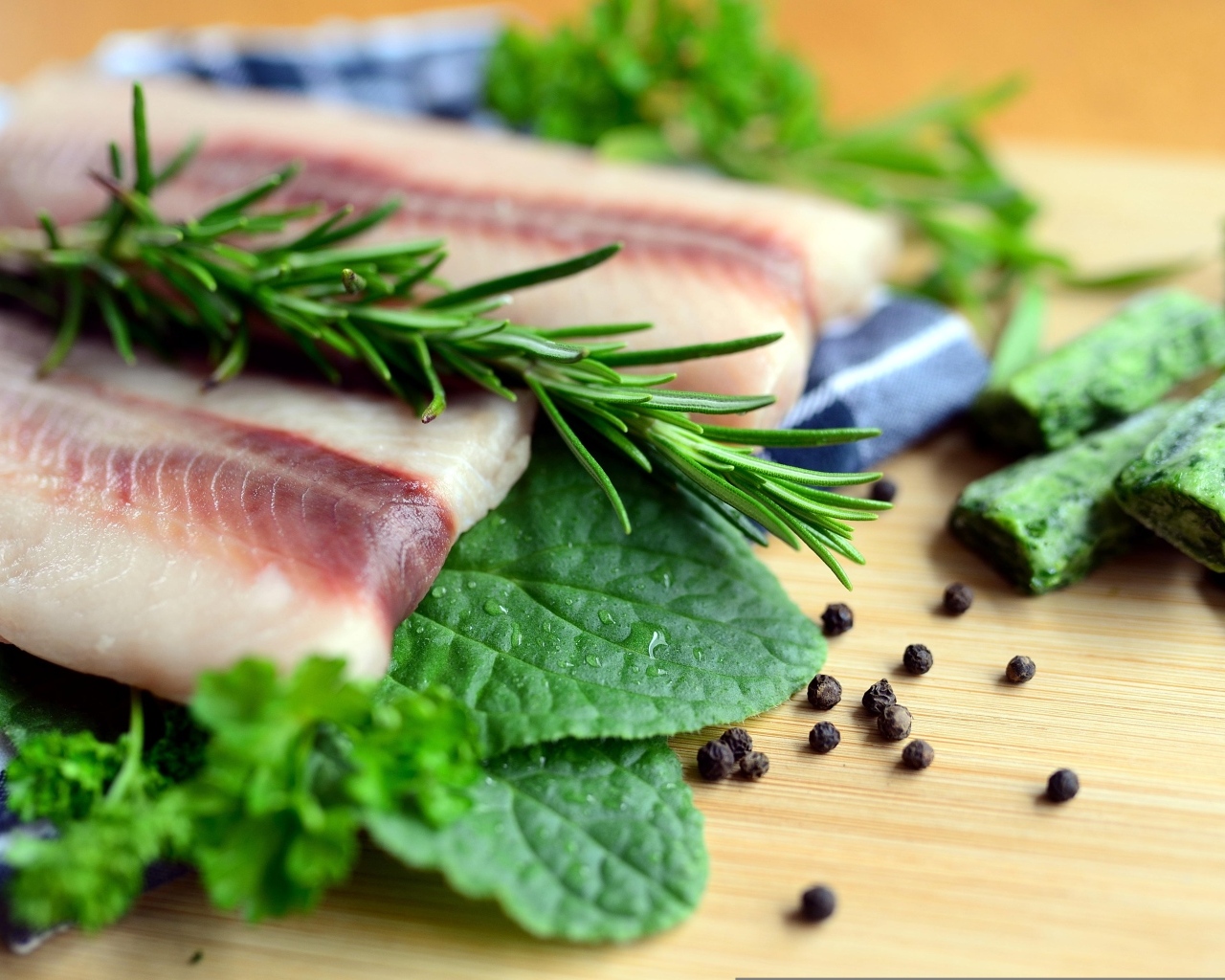 Свежая рыба на доске с зеленью и специями