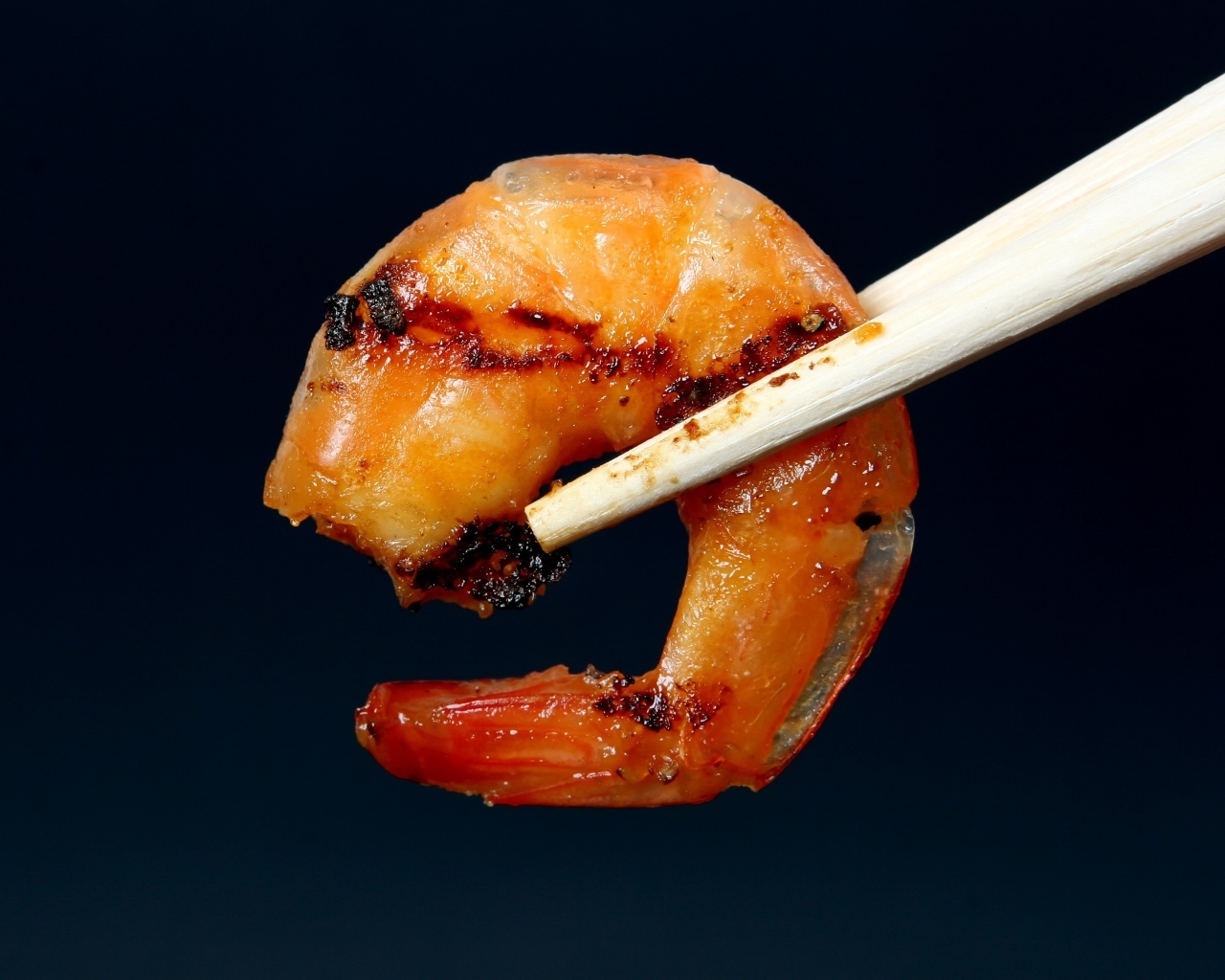 Жареная креветка с палочками на черном фоне