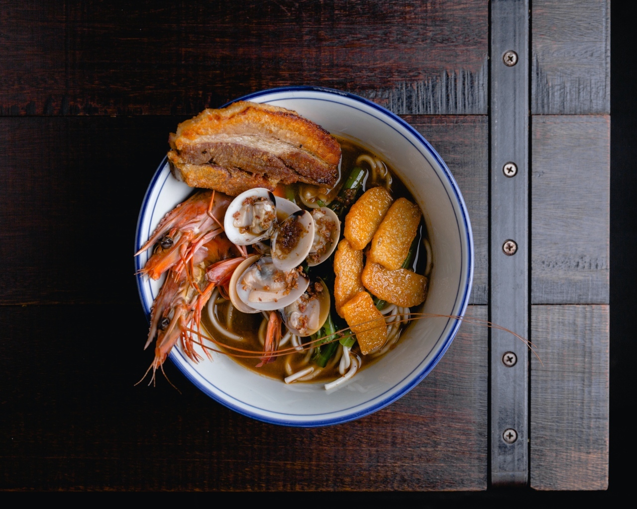Суп с лапшой и морепродуктами на деревянном столе