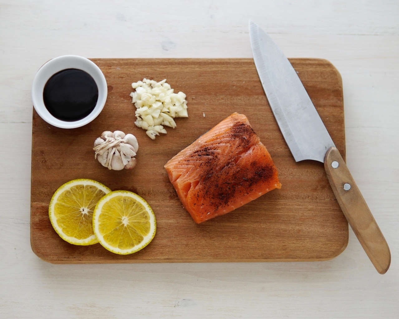 Кусок красной рыбы на доске с лимоном и чесноком