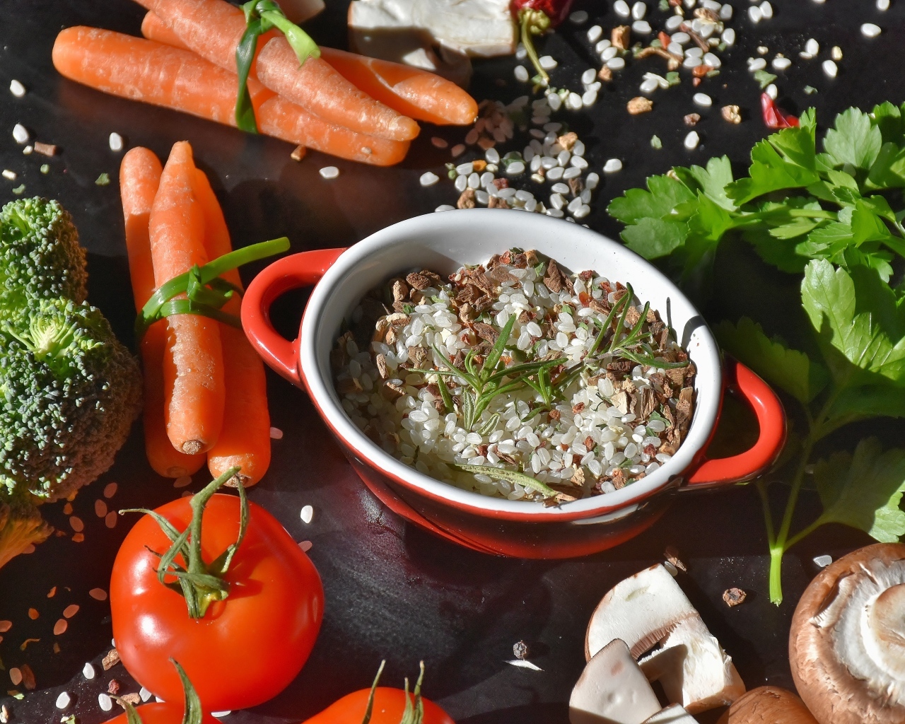 Рис на столе с морковью, помидорами и грибами